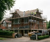 Scaffolding and materials on a Cheshire house during a full roof replacement, highlighting factors that affect the cost.